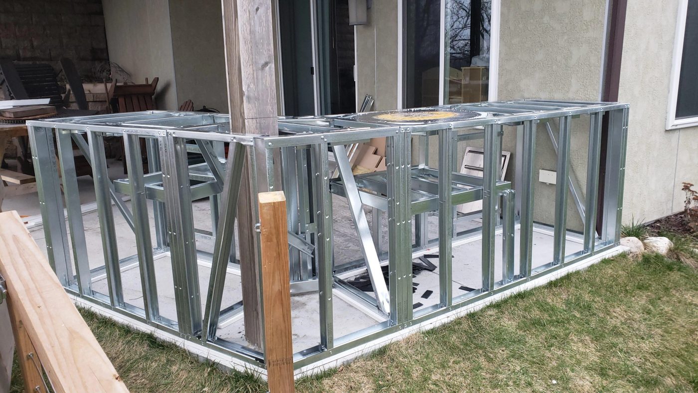 Galvanised steel framing for an outdoor kitchen run, set out on a patio before cladding