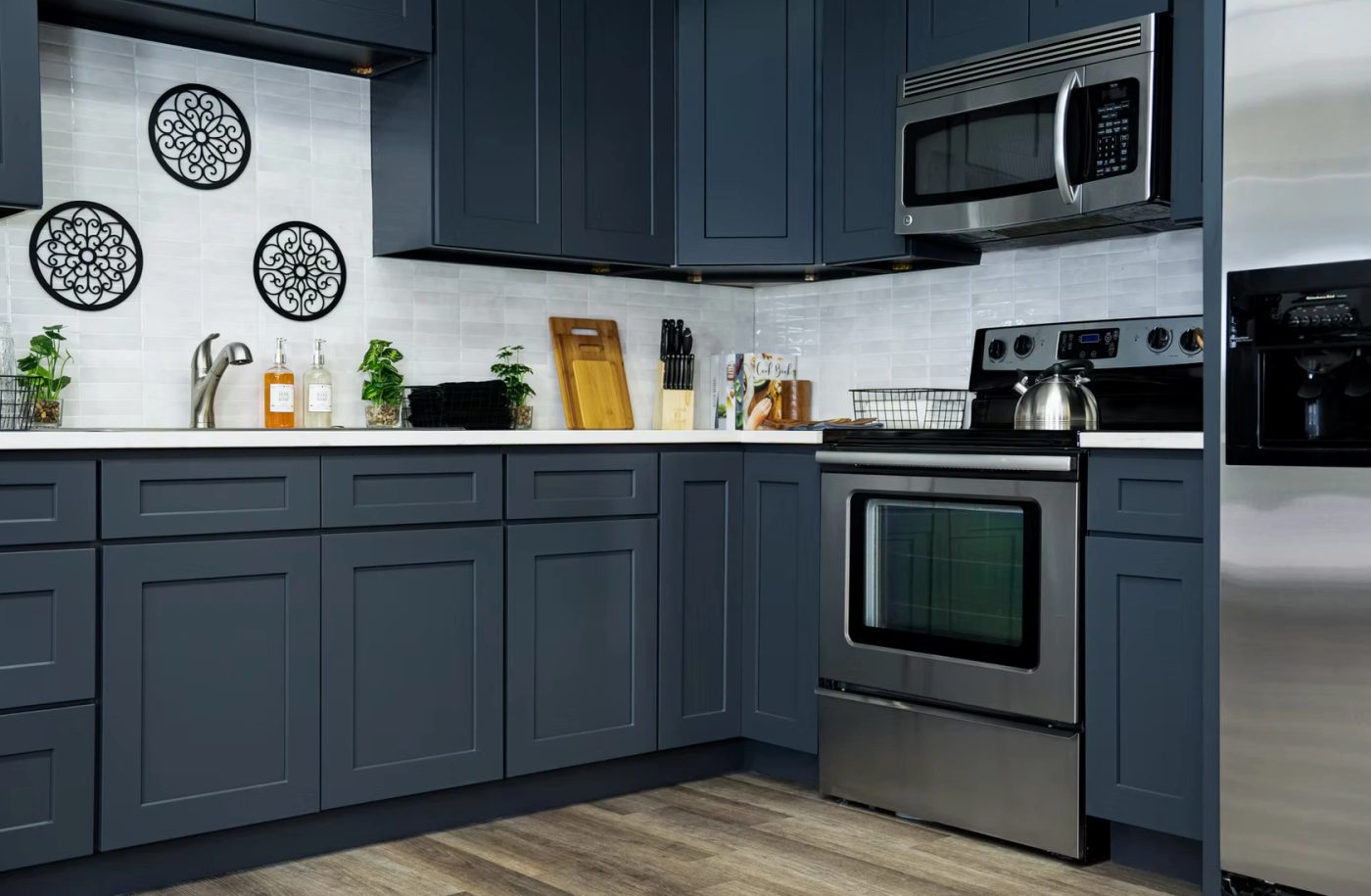 Slate blue shaker kitchen cabinets with white quartz countertops and a white tile backsplash